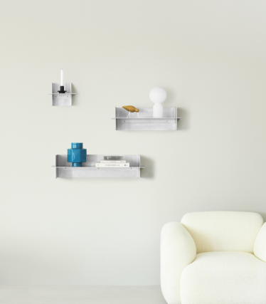 Przezroczyste półki ścienne Normann Copenhagen z dekoracyjnymi akcesoriami w minimalistycznej przestrzeni mieszkalnej.