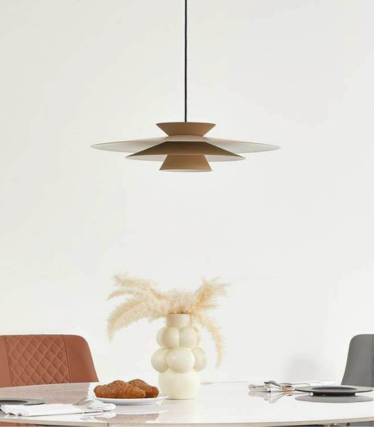 Nowoczesna lampa wisząca nad stołem jadalnym w ciepłych naturalnych tonach i ponadczasowym designem.